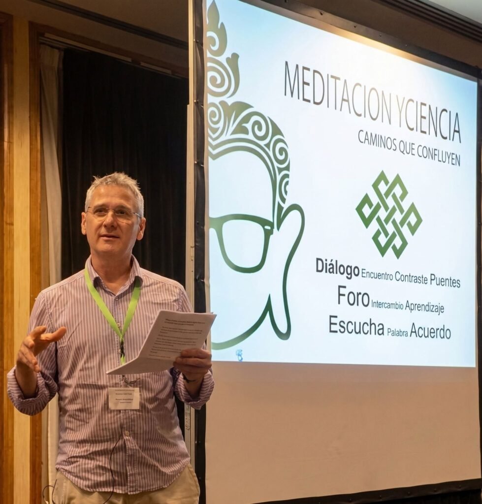 Dharmakirti Zuázquita da un taller ante una pantalla con el título «Meditación y ciencia: caminos que confluyen»
